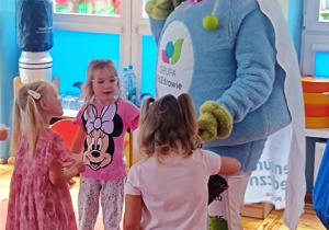 Dzieci witają się z maskotką witającą ich w przedszkolu w nowym roku szkolnym