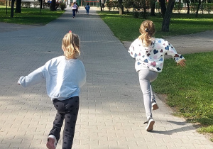 Dzieci biegną alejką parkową