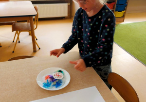 Dziewczynka robi eksperyment tworząc kolorowe kropki