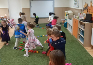Dzieci biorą udział w zabawie ruchowej w sali