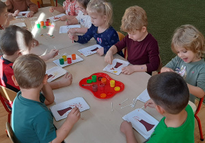 Dzieci malują farbami liście drzew