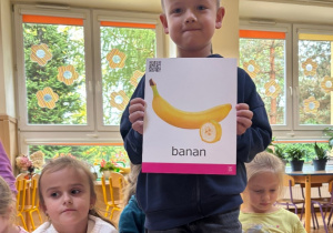 Chłopiec pokazuje ilustrację przedstawiająca banana