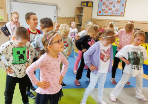 Dzieci ćwiczą w sali przedszkolnej
