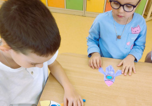 Dzieci wykonują rakiety kosmiczne z papieru i bibuły