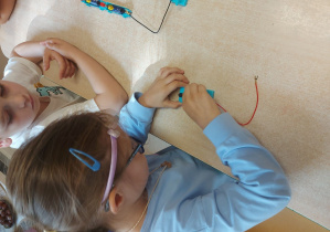Dzieci budują obwód elektryczny z użyciem żarówki