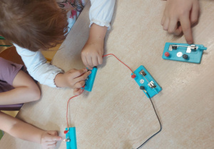 Dzieci budują obwód elektryczny z użyciem żarówki