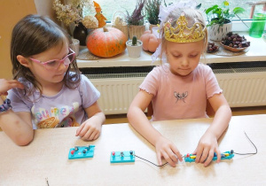 Dzieci budują obwód elektryczny z użyciem żarówki