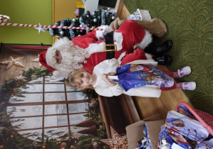 Dziewczynka pozuje z Mikołajem do zdjęcia