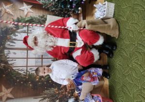 Chłopiec pozuje z Mikołajem do zdjęcia