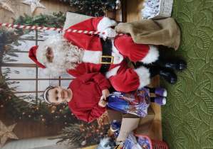 Dziewczynka pozuje z Mikołajem do zdjęcia