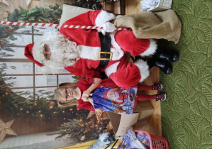 Dziewczynka pozuje z Mikołajem do zdjęcia