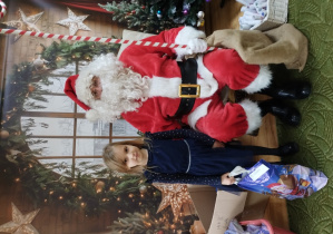 Dziewczynka pozuje z Mikołajem do zdjęcia