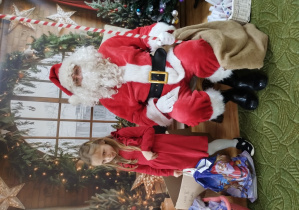 Dziewczynka pozuje z Mikołajem do zdjęcia