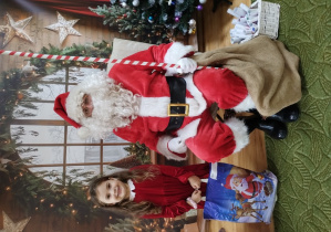 Dziewczynka pozuje z Mikołajem do zdjęcia