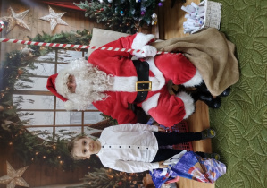 Chłopiec pozuje z Mikołajem do zdjęcia