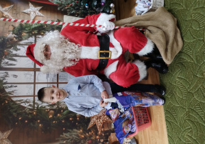 Chłopiec pozuje z Mikołajem do zdjęcia