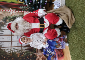 Chłopiec pozuje z Mikołajem do zdjęcia