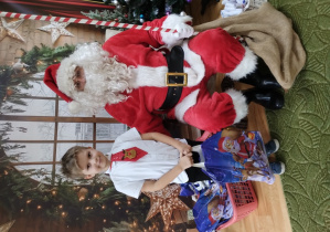 Chłopiec pozuje z Mikołajem do zdjęcia