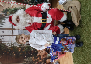 Chłopiec pozuje z Mikołajem do zdjęcia