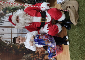 Chłopiec pozuje z Mikołajem do zdjęcia