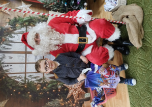 Chłopiec pozuje z Mikołajem do zdjęcia