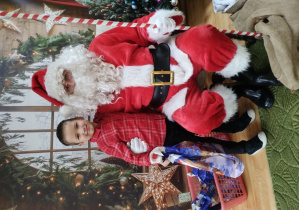 Chłopiec pozuje z Mikołajem do zdjęcia