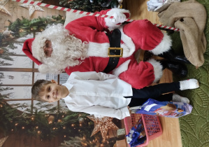 Chłopiec pozuje z Mikołajem do zdjęcia