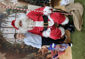 Chłopiec pozuje z Mikołajem do zdjęcia