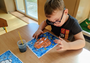 Chłopiec kończy pracę plastyczną