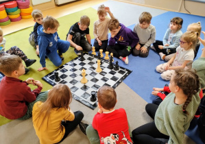 Dzieci ćwiczą poruszanie się figur na szachownicy