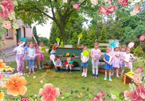 Dzieci pozują do zdjęcia grupowego w ogrodzie przedszkolnym
