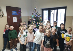 Dzieci pozują do zdjęcia przy choince