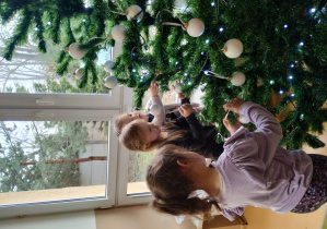 Dziewczynki ubierają choinkę