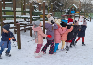 Dzieci na placu zabaw bawią się na śniegu