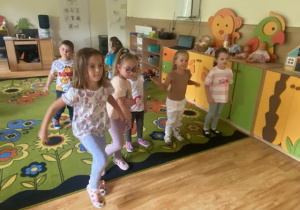 Dzieci tańczą na dywanie