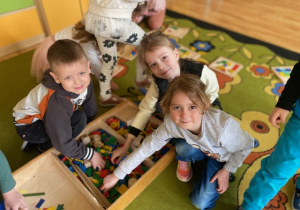 Dzieci układają mozaikę geometryczną