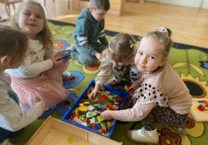 Dzieci układają mozaikę geometryczną