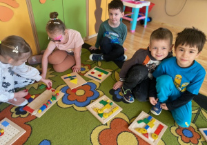 Dzieci układają mozaikę geometryczną