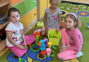 Dziewczyny układają kwiaty plastikowe