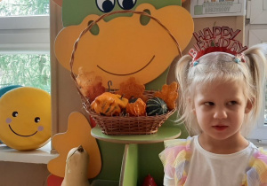 Dziewczynka pozuje do zdjęcia w sali przedszkolnej