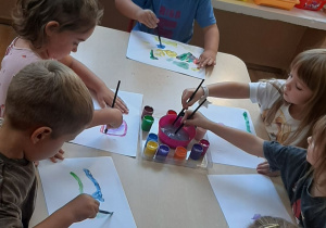 Dzieci wykonują pracę plastyczną farbami