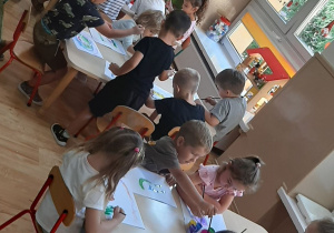 Dzieci wykonują pracę plastyczną farbami