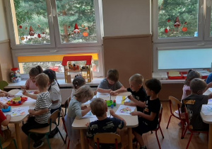 Dzieci wykonują pracę plastyczną farbami