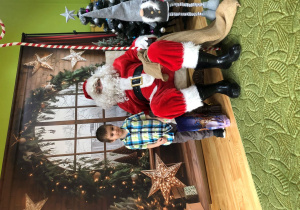 Dziecko pozuje do zdjęcia z Mikołajem