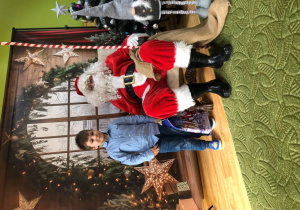 Dziecko pozuje do zdjęcia z Mikołajem