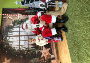 Dziecko pozuje do zdjęcia z Mikołajem