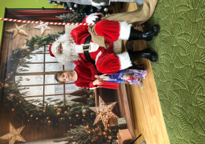 Dziecko pozuje do zdjęcia z Mikołajem