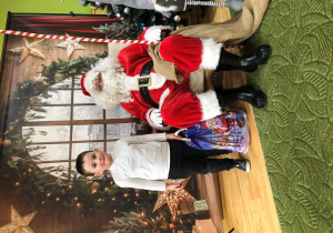 Dziecko pozuje do zdjęcia z Mikołajem