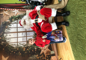 Dziecko pozuje do zdjęcia z Mikołajem