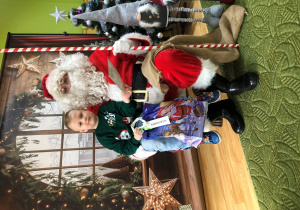 Dziecko pozuje do zdjęcia z Mikołajem